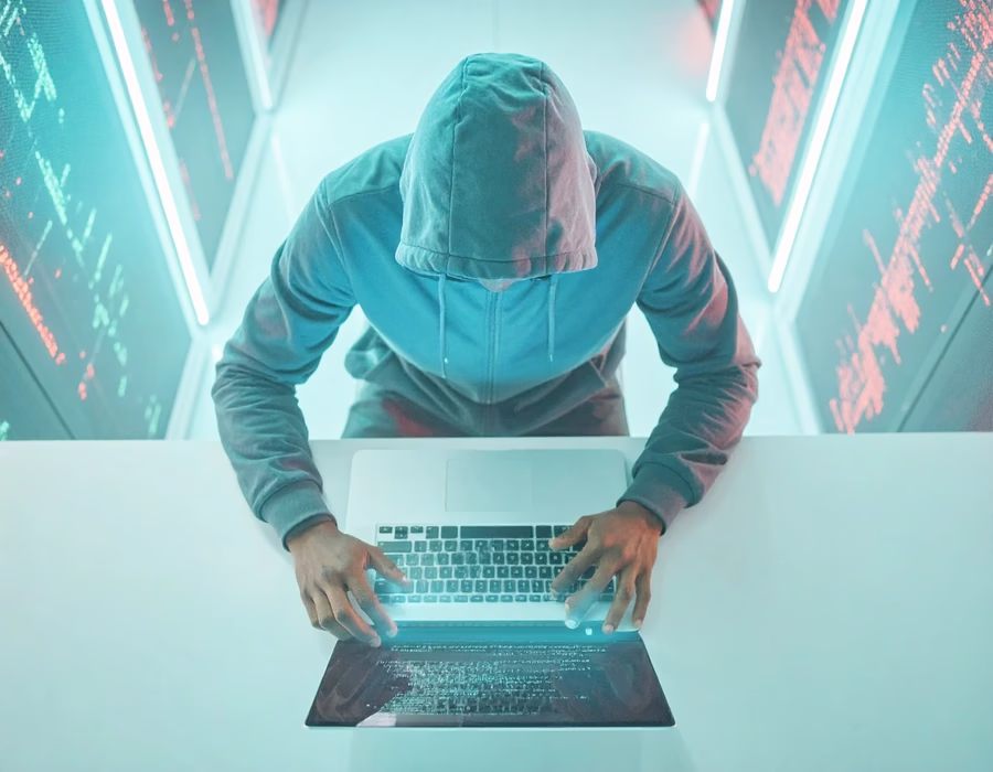 Zero-Day Vulnerabilities: Hacker working on laptop in darkness.